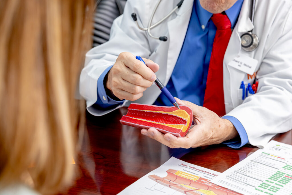 A medical professional holds a figure of an artery while discussing options for a blood cholesterol test in Rocky Mount.