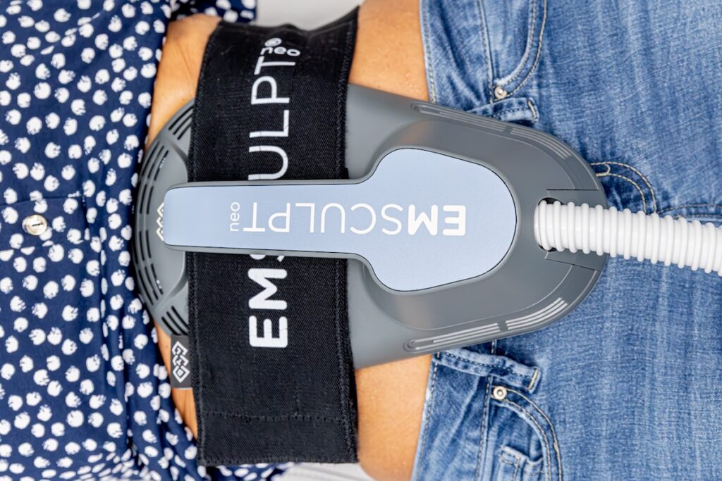 A close-up of an Emsculpt NEO applicator on a patient's abdomen for body contouring in Rocky Mount.